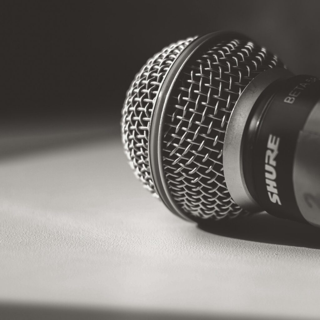 Artistic close-up of a Shure microphone in black and white, showcasing intricate details.
